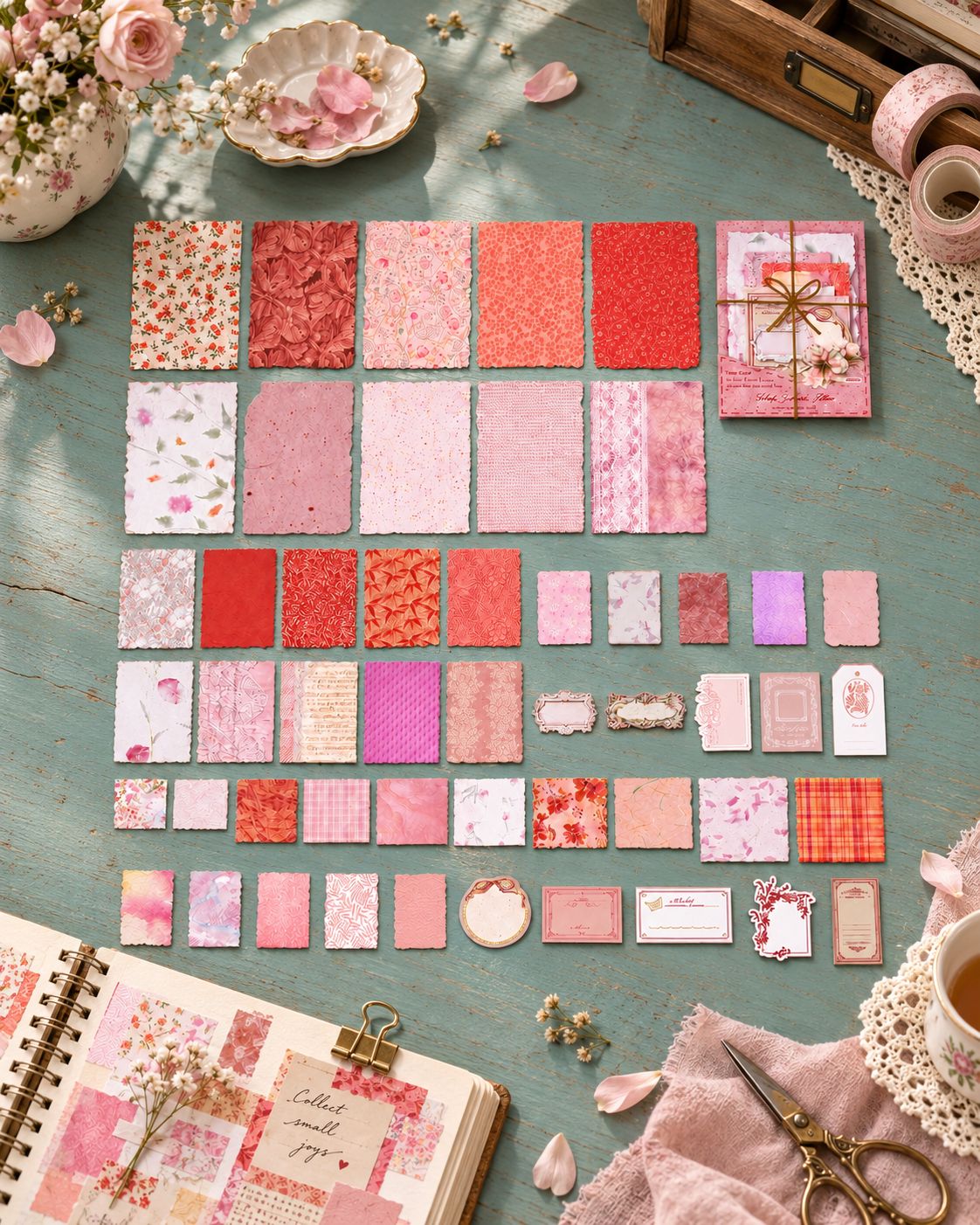 Pink patterned scrapbook papers arranged on linen with flowers and lace