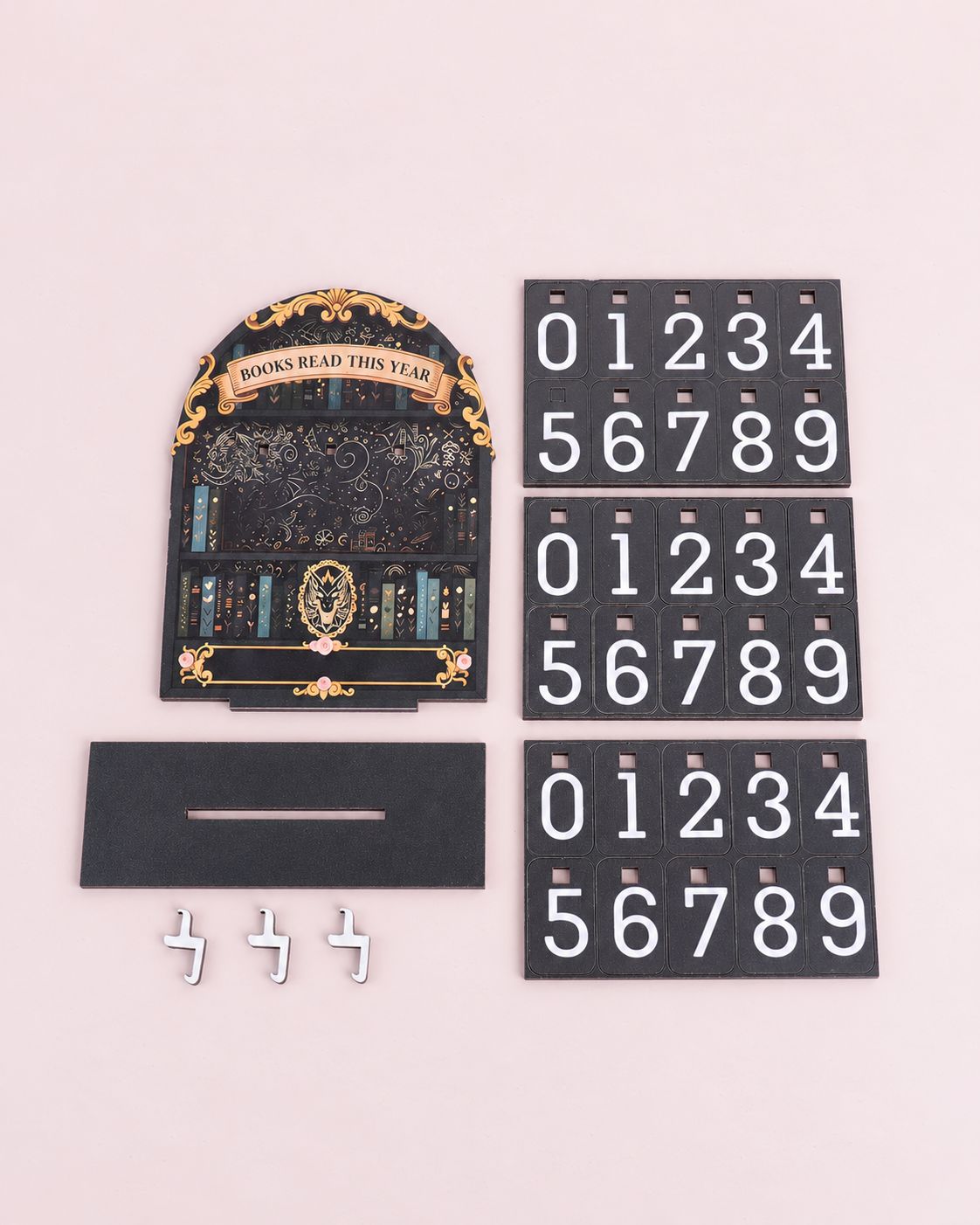 Reading counter kit laid flat: an illustrated bookshelf board, a slotted base, three hooks and three sheets of number cards