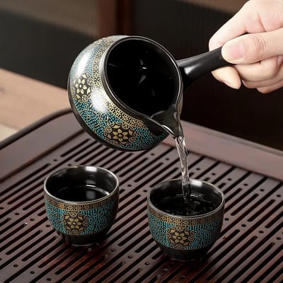 Matching pitcher pouring into teal floral cups.