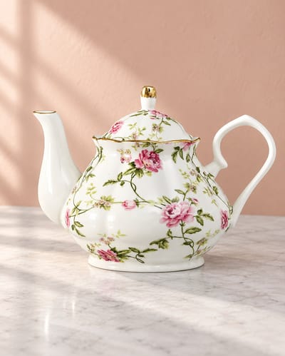 White floral teapot with a matching lid, pink flowers and gold trim.